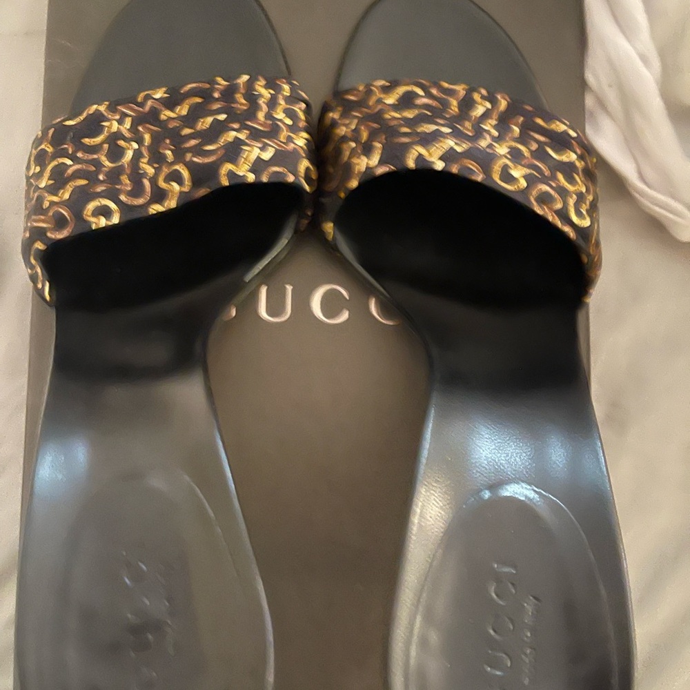 Black and gold Gucci slides